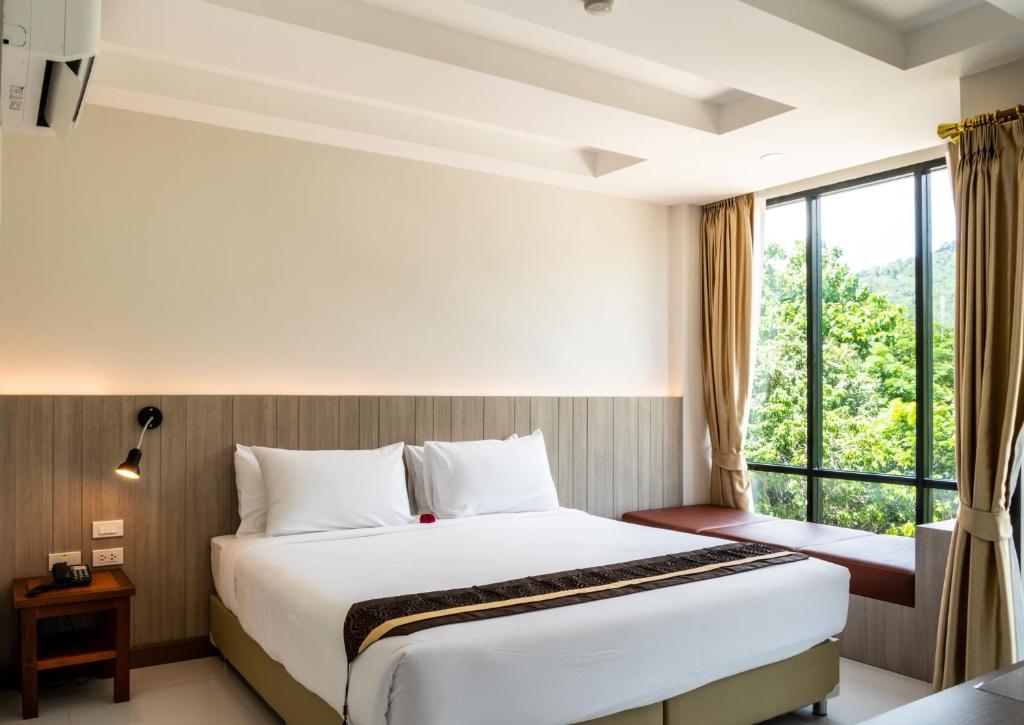 慕斯Ozone Hotel Khao Yai的酒店客房设有床和窗户。