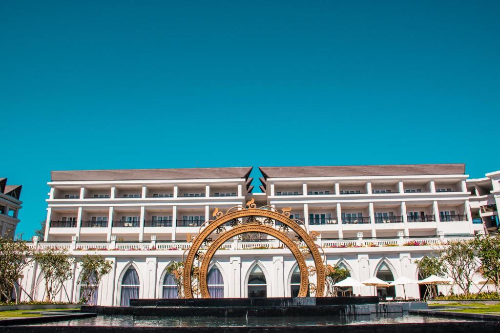美奈美奈湾度假酒店的一座白色的大建筑,前面有拱门
