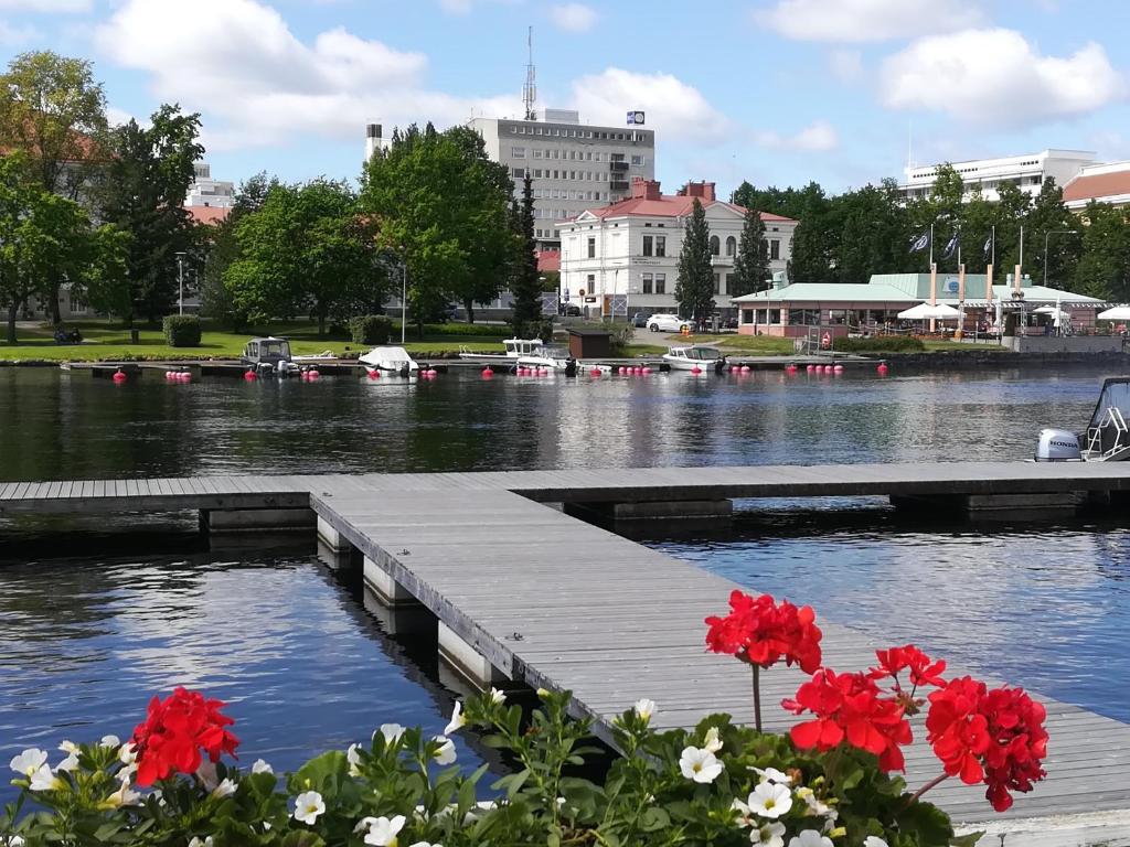 萨翁林纳Savonlinna Rentals的河上一座有红花的码头,有建筑
