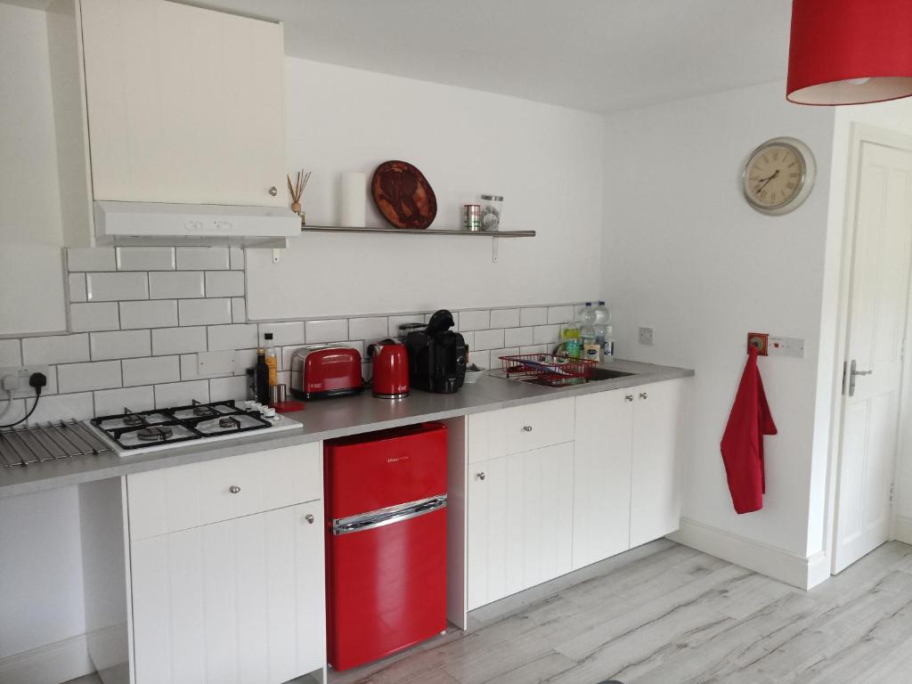韦斯特波特Pier Road Cottage, Croagh Patrick的厨房配有红色冰箱和白色橱柜