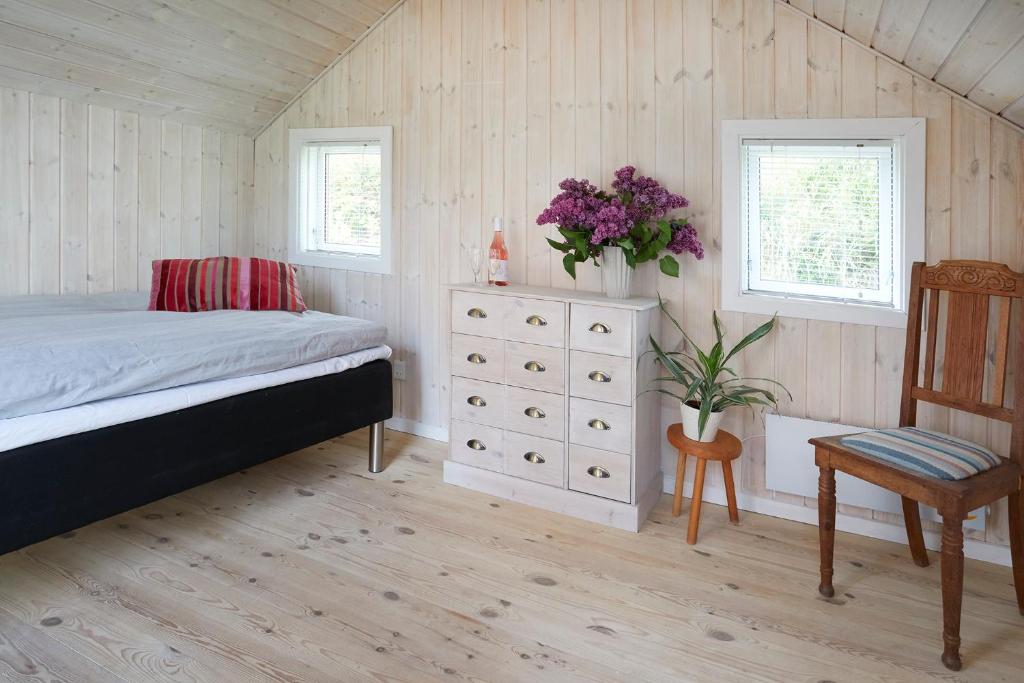 斯坎讷堡Brørup Kjærsgaard, Hygge, ro, natur og landliv的一间卧室配有一张床、梳妆台和椅子