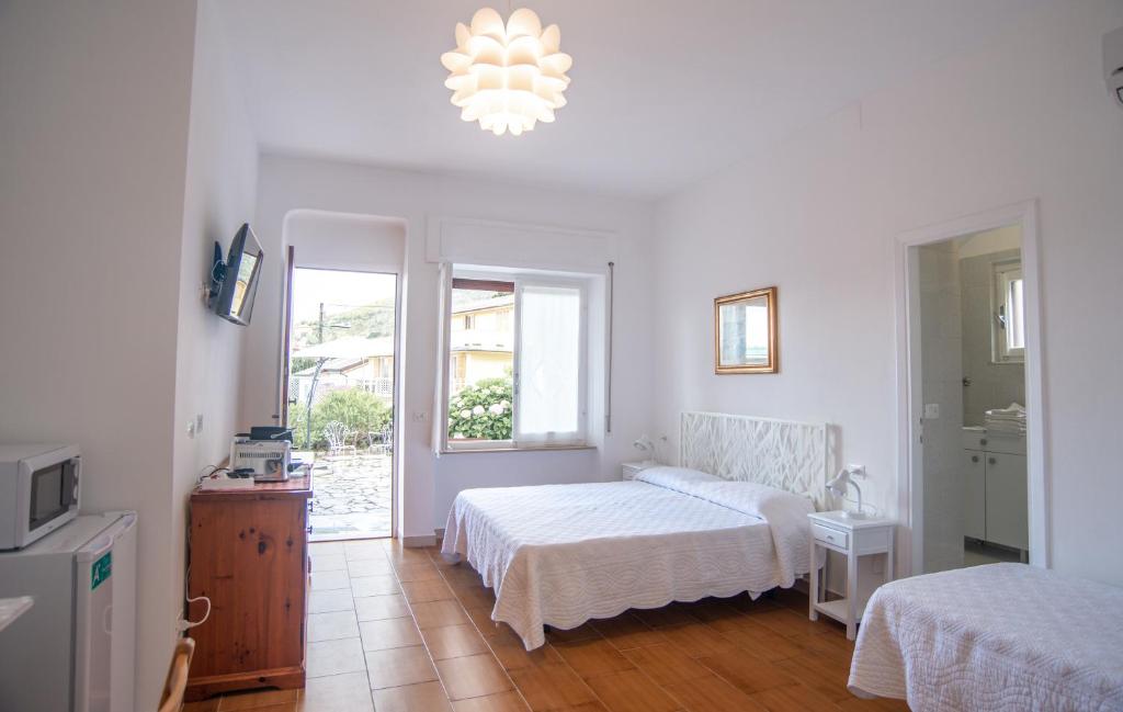 莱万托Villa Mori的一间白色卧室,配有两张床和窗户