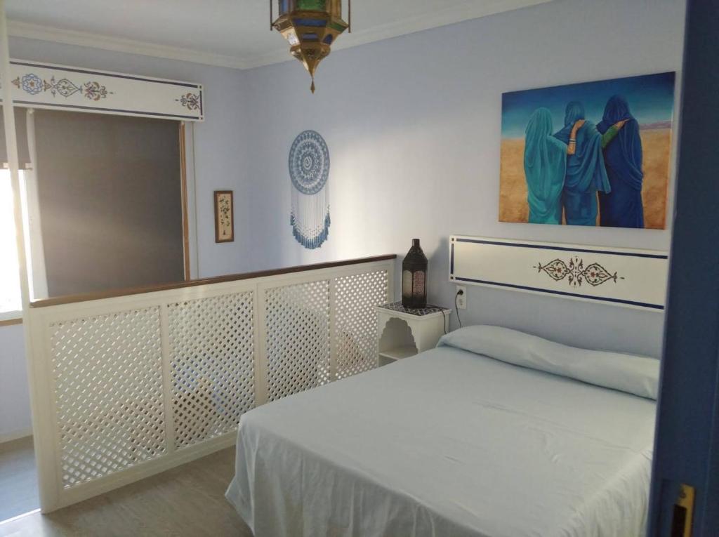 桑卢卡尔-德巴拉梅达El apartaito的卧室配有白色的床和墙上的绘画作品