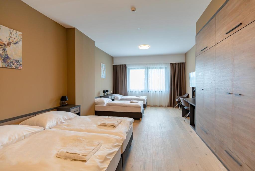 贾尔A22 Hotel Gyál的酒店客房配有两张床和一张书桌