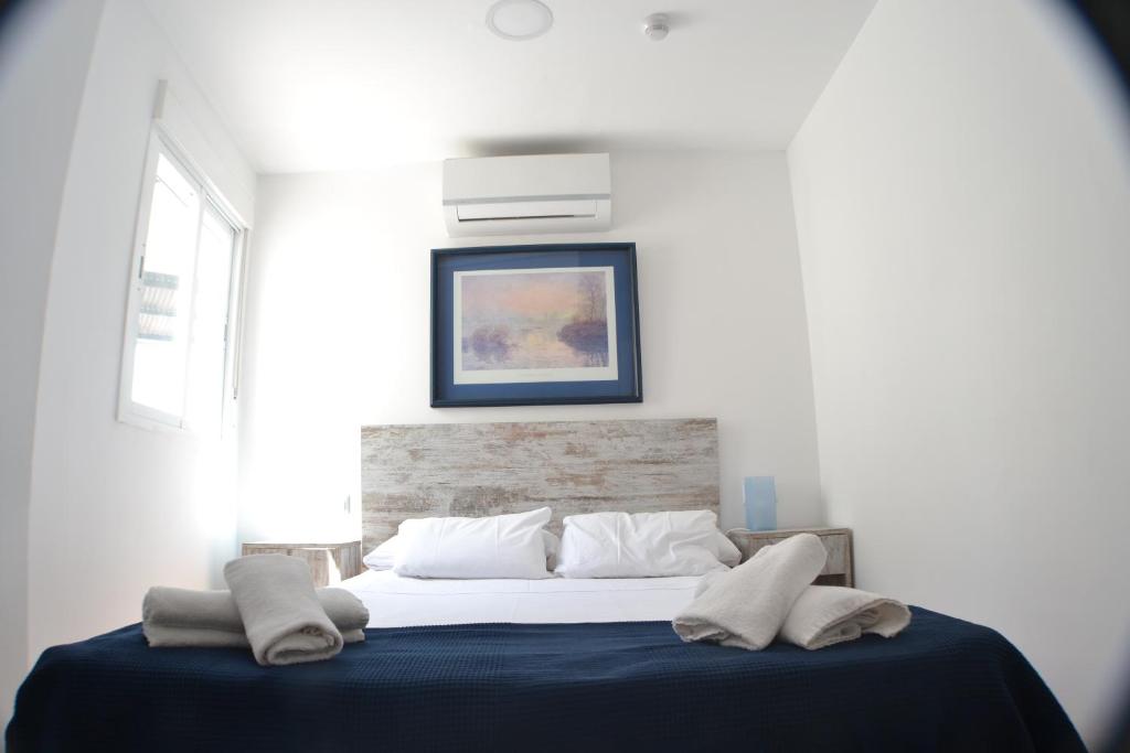 马拉加诺玛达斯精品酒店的一间卧室配有一张带蓝色毯子的床