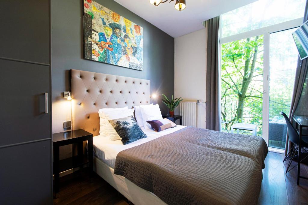 阿姆斯特丹昆汀英格兰酒店的一间卧室设有一张大床和一个大窗户