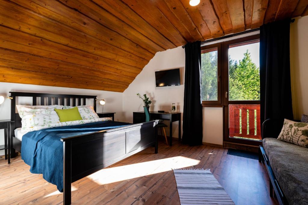 日亚尔Ubytovanie&Reštaurácia Bodliak的一间卧室设有一张床和木制天花板