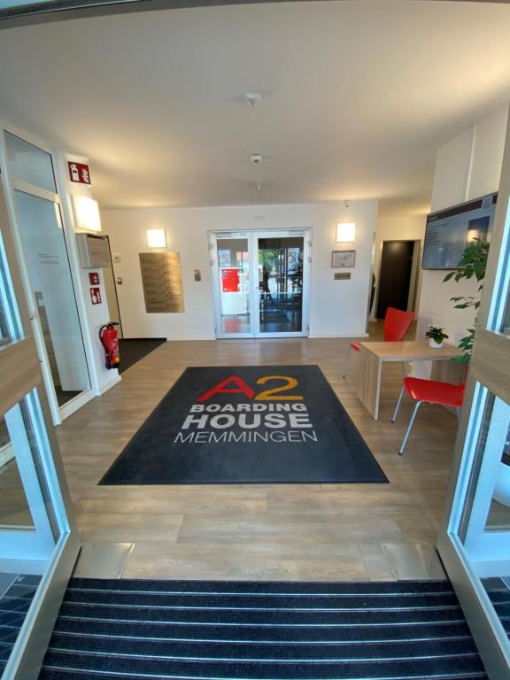 梅明根A2 Boarding House Memmingen的办公室大堂,地板上铺着地毯
