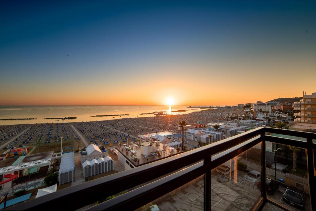 卡托利卡Rex Residence Hotel的阳台享有日落海滩的景致。