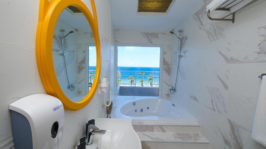 安塔利亚Sea City Devran Hotel & Spa的浴室配有盥洗盆、镜子和浴缸