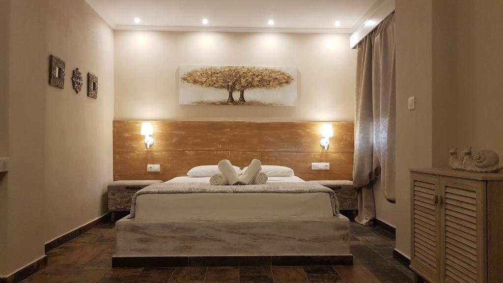 埃利亚Agrili Apartments & Rooms的卧室配有一张床铺,墙上挂着一棵树