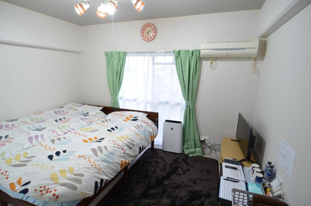 宫崎Amont Nakamura - Vacation STAY 83274的一间卧室配有一张床、一台电视和一个窗口