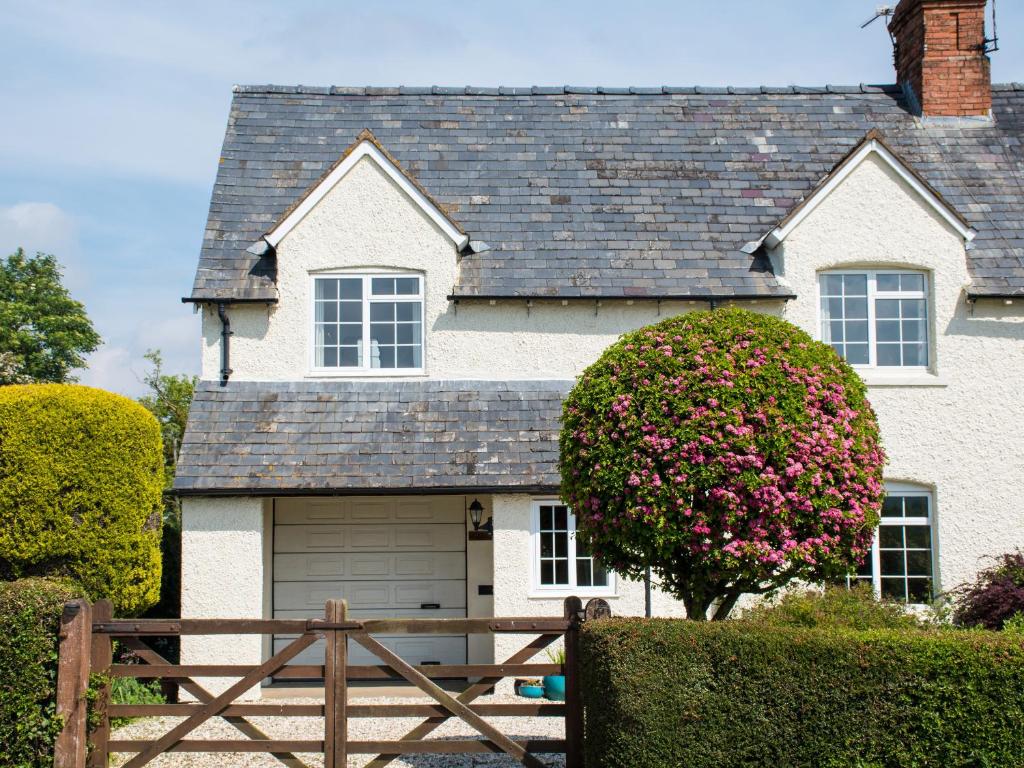 布罗德韦Glencoe Cottage的白色的房子,设有车库和围栏
