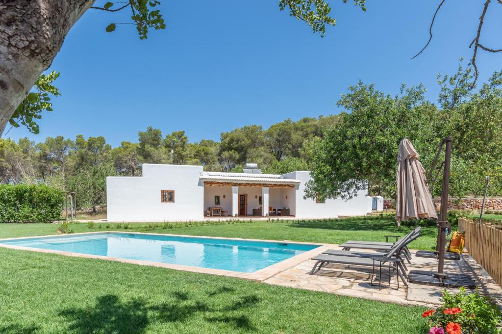 圣埃乌拉利亚Casa rural es Murtà的一座带游泳池和房子的别墅