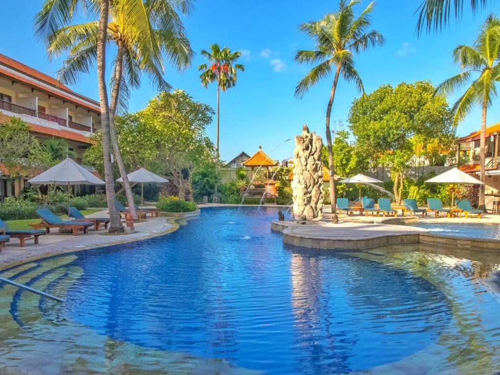 库塔巴厘岛拉尼酒店的棕榈树度假村的游泳池