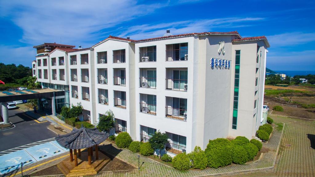 济州市Hi Jeju Hotel的享有白色建筑空中美景,设有游泳池