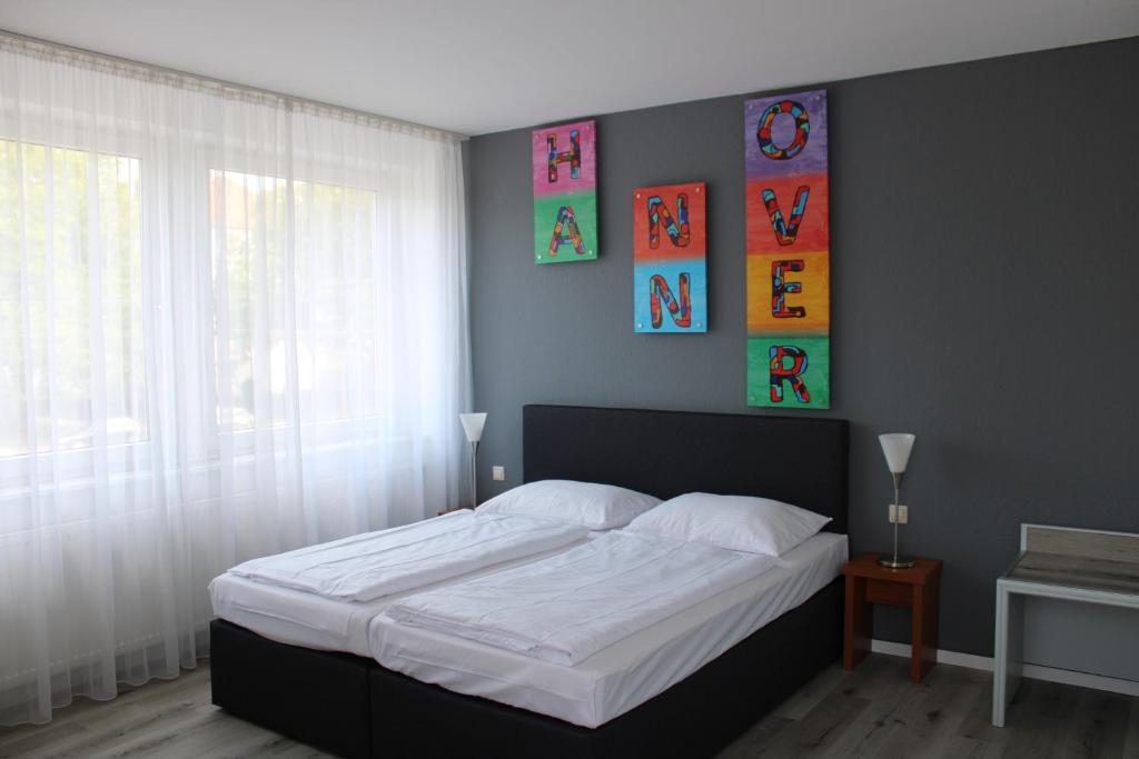汉诺威Plaza Inn Hannover City Nord的一间卧室配有一张带白色床单的大床