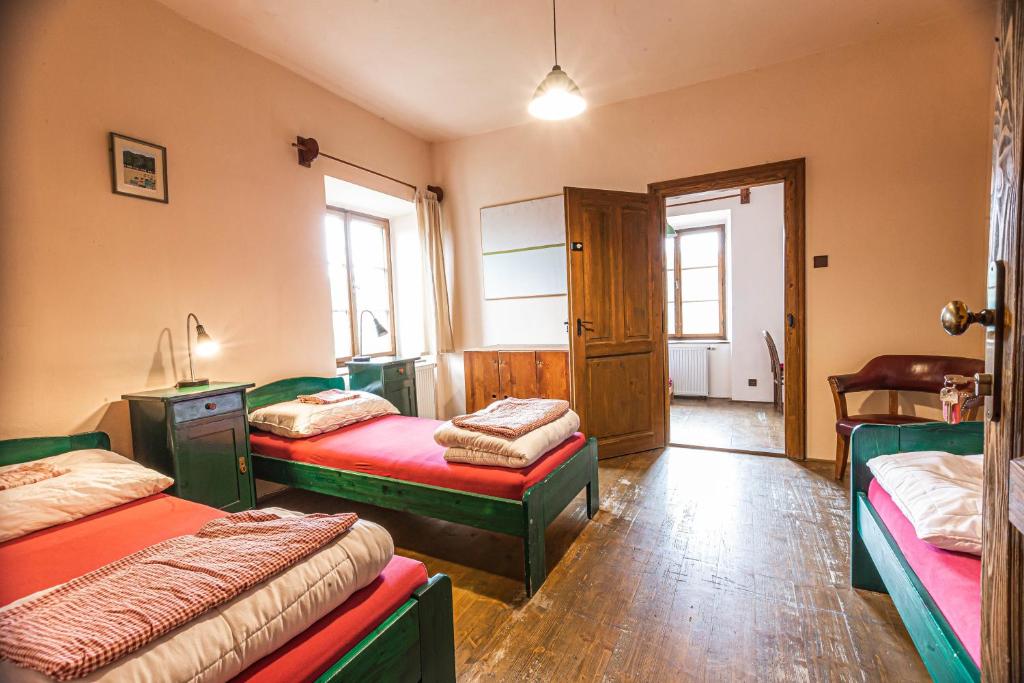 捷克克鲁姆洛夫99号旅馆的一间卧室设有两张床,一扇门设有窗户