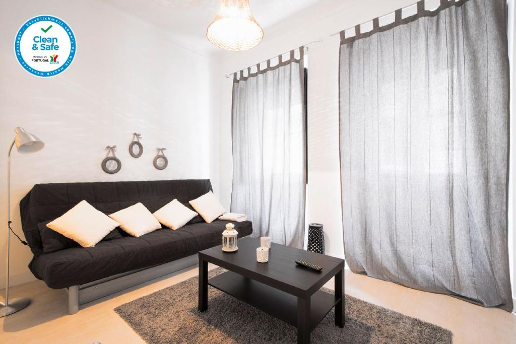 里斯本Trendy Alcantara Apartment的客厅配有黑色沙发和桌子