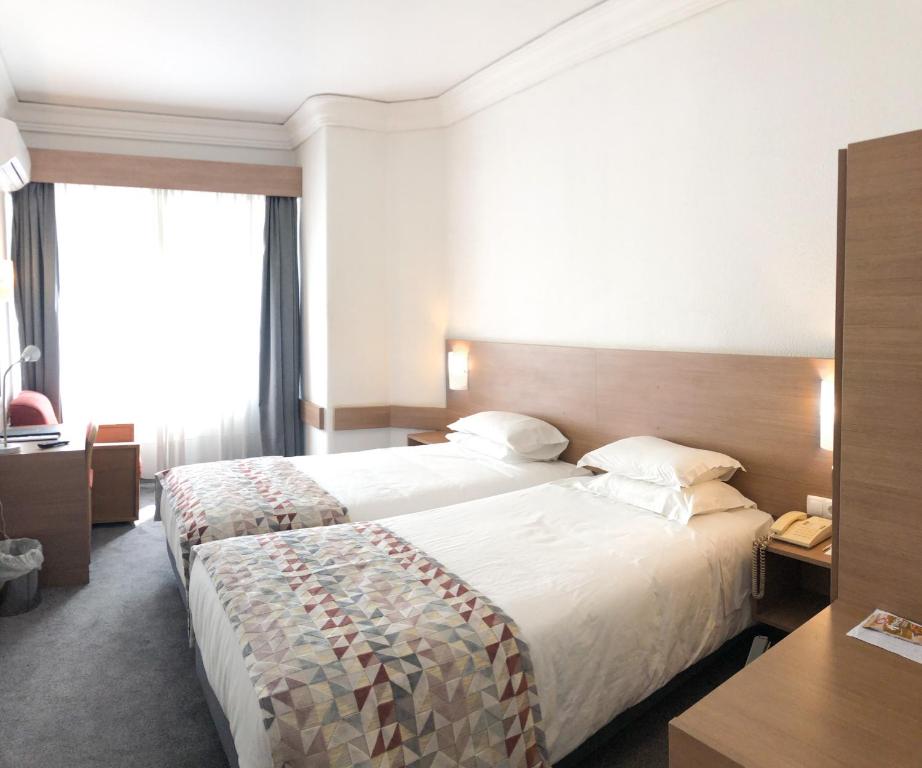 里斯本佛拉明哥酒店的酒店客房配有两张床和一张书桌