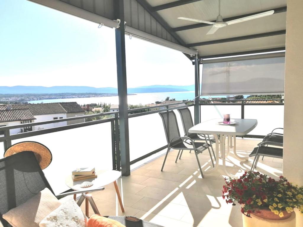 马林斯卡Lovely Sea View House in Malinska Island Krk的阳台配有桌椅,享有海景。