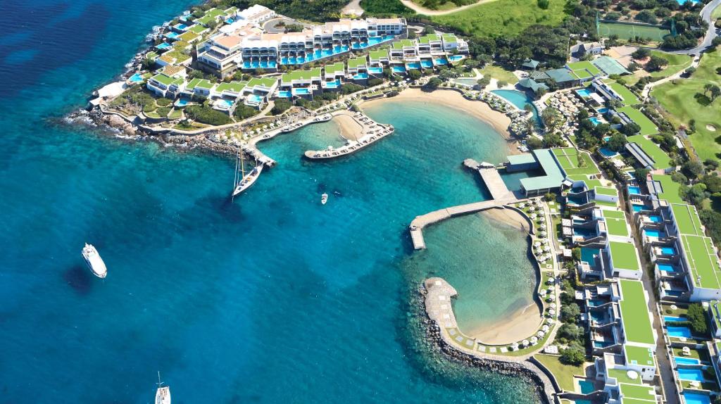 伊罗达Elounda Peninsula All Suite Hotel, Six Senses Spa的水上船只的度假村空中景观