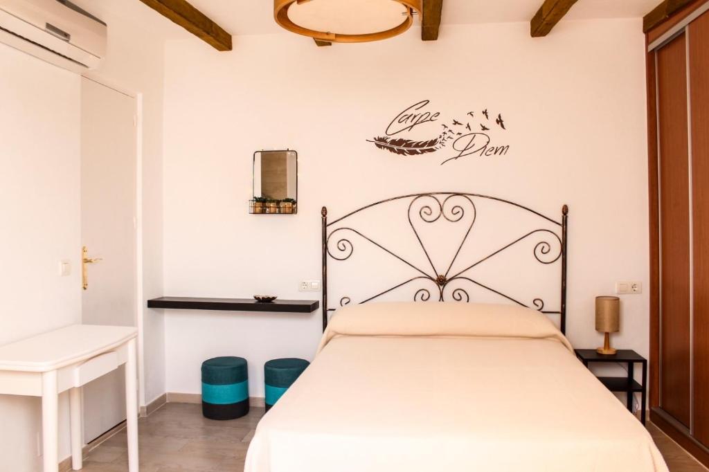 贝纳尔马德纳Apartamentos La Mar Chica的卧室配有一张床,墙上有标志