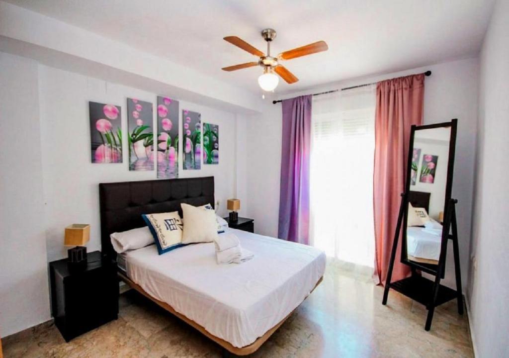 滨海罗克塔斯Expoholidays - Estrella del Mar的一间卧室配有一张床和吊扇