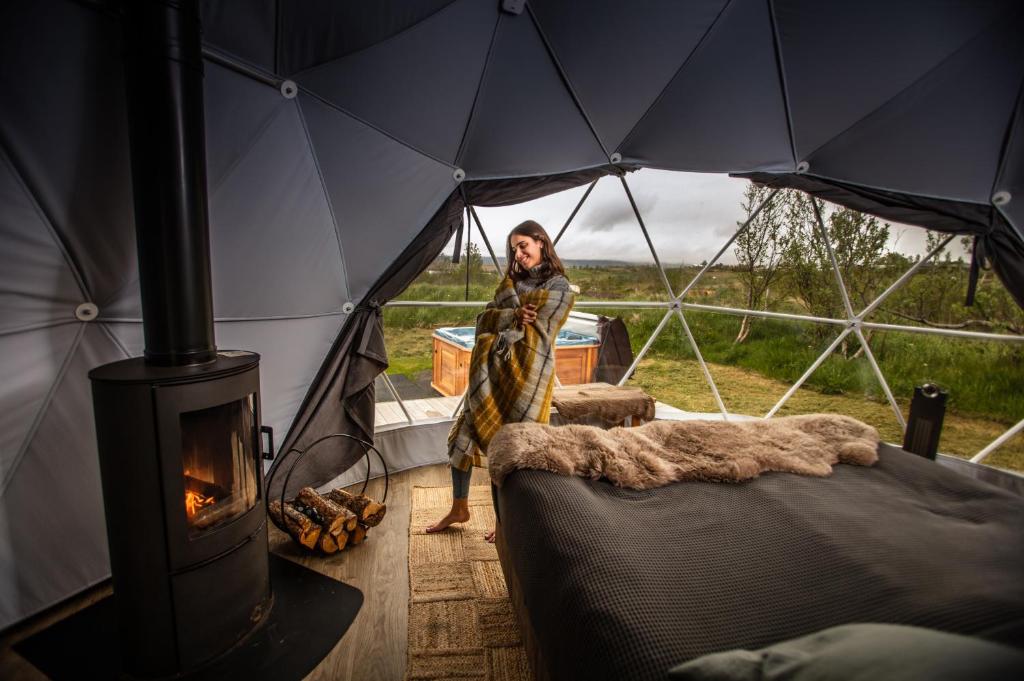 雷克雅未克Reykjavik Domes的站在带炉灶的帐篷内的女人