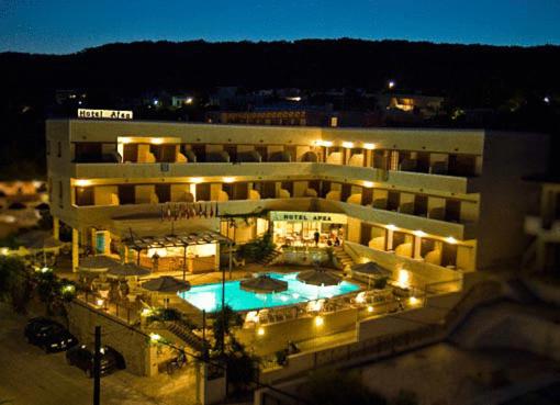 阿吉亚玛丽娜Hotel Afea的一座大型建筑,晚上设有游泳池