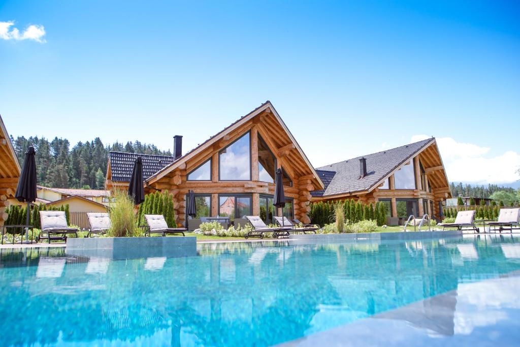 巴尼亚Alpina Luxury Chalets的小木屋,设有游泳池和房屋