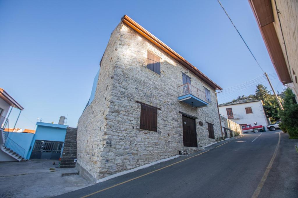 帕诺雷弗卡拉艾奥斯费斯石头度假屋的街边的一栋砖砌建筑