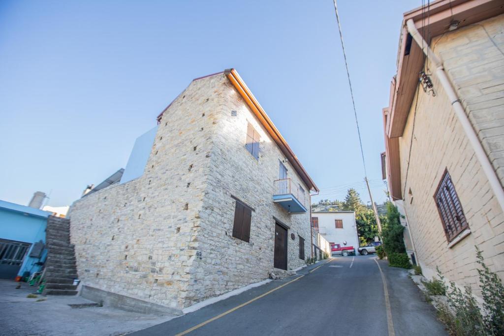 帕诺雷弗卡拉艾奥斯费斯石头度假屋的一条空的街道,靠近石头建筑