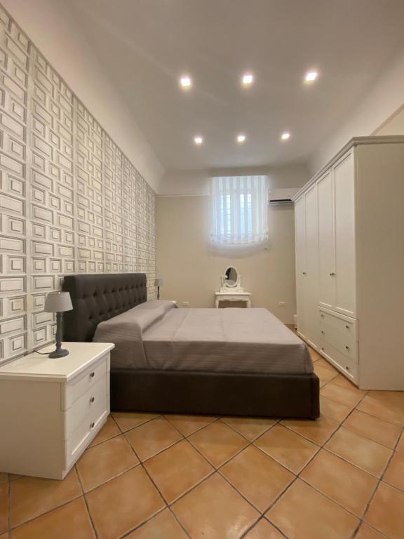 庞贝La casa di Vesta的一间卧室配有一张大床和一个白色的橱柜