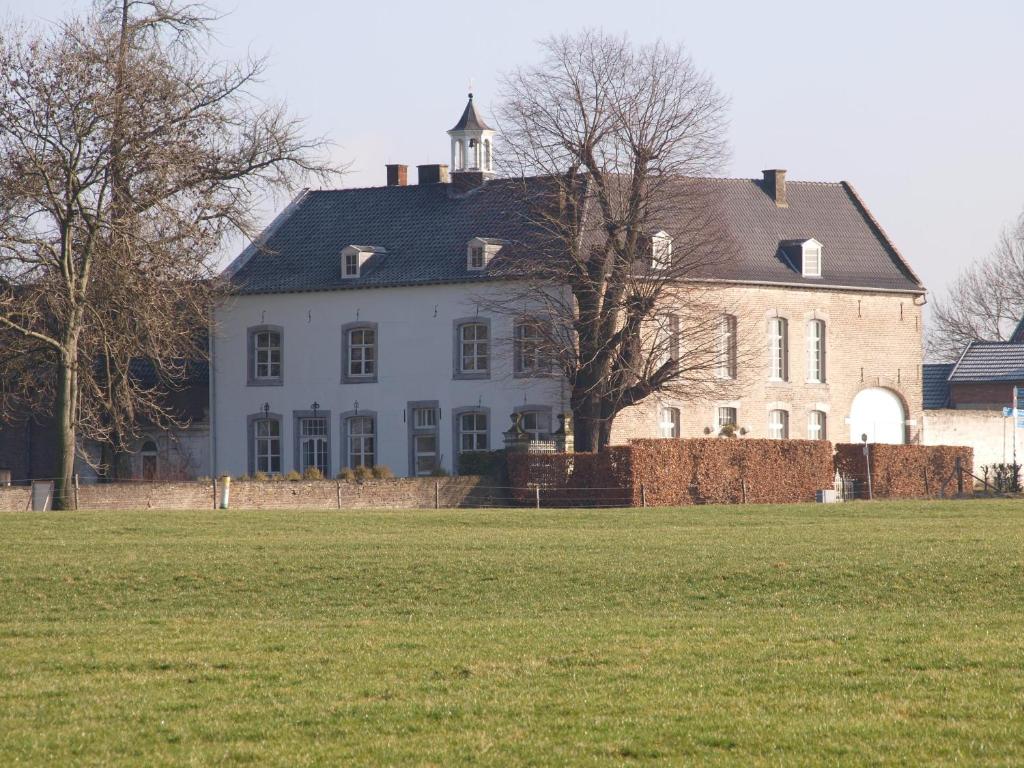 贝梅伦布登普拉特贝米林住宿加早餐旅馆的前面有田野的大白色房子