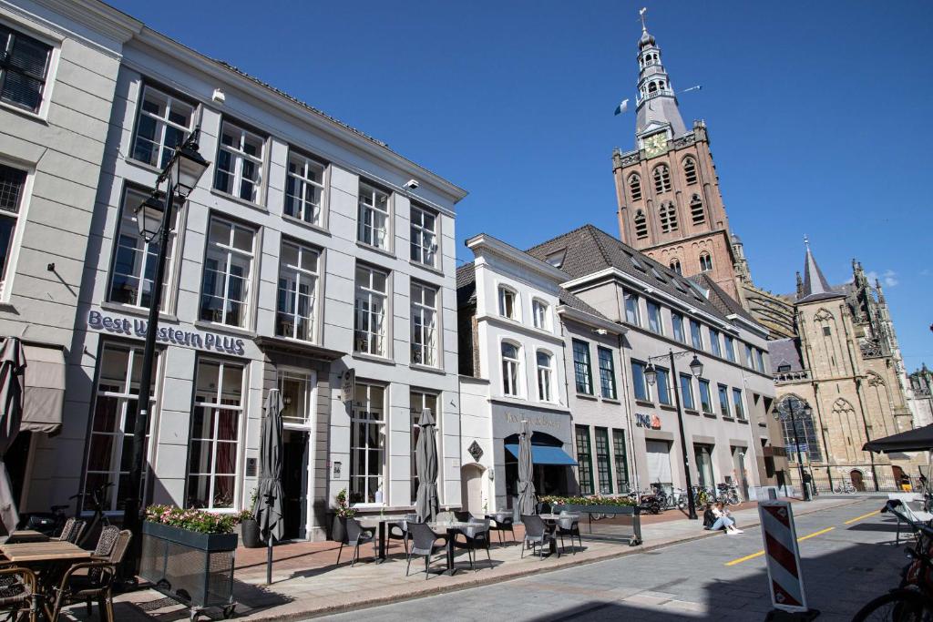 登博斯Good Seasons City Centre Hotel Den Bosch的一条拥有白色建筑和钟楼城市街道