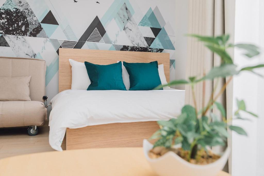 大阪Juso AFP Apartment Hotel的一间卧室配有一张带蓝色枕头和植物的床