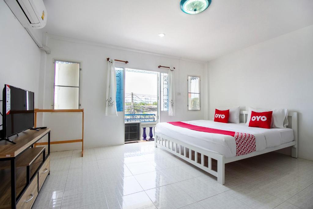 华欣OYO 908 Sabai Place的白色卧室设有一张大床和电视。