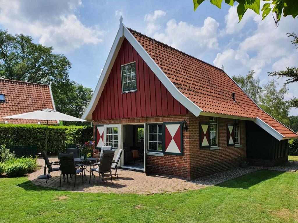利费尔德Lekker Plekje Achterhoek的院子里的红色谷仓,配有桌椅