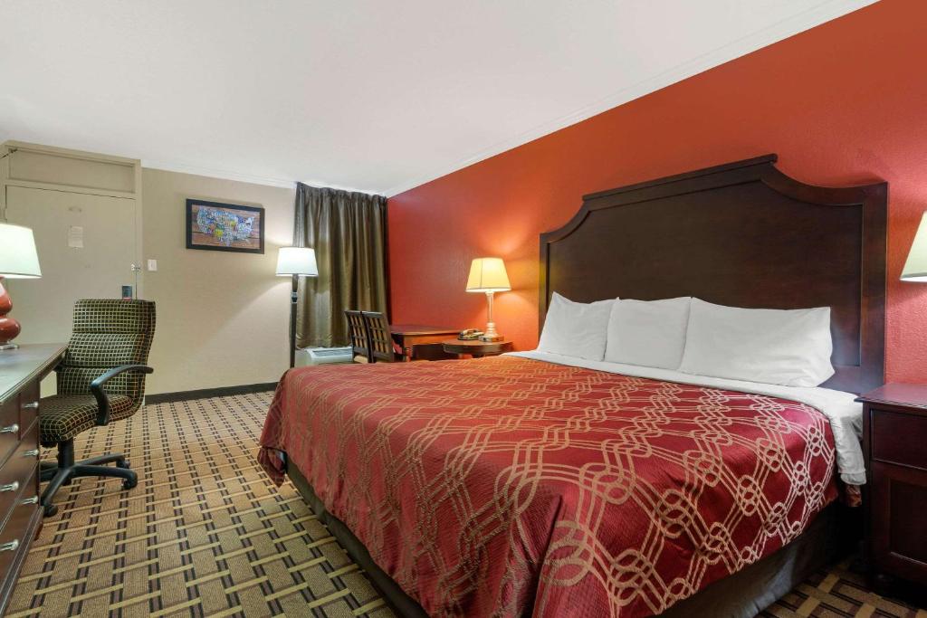 海恩斯维尔Econo Lodge Near Fort Stewart, Bar, Restaurant, Laundry Facility的配有一张床和一张书桌的酒店客房