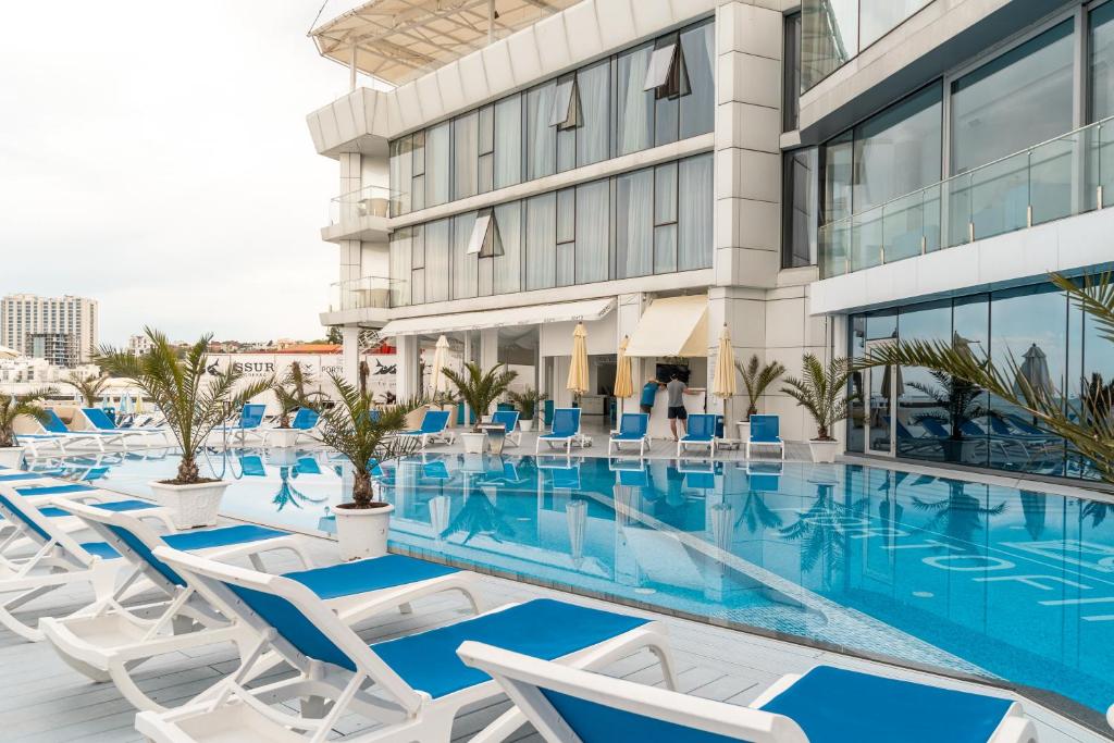 敖德萨波特费诺精品酒店的一座带椅子的游泳池以及一座建筑