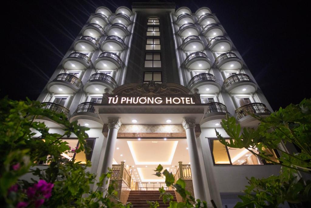 清化Khách sạn Tú Phương - Hải Tiến的一座有灯的建筑,上面有酒店标志