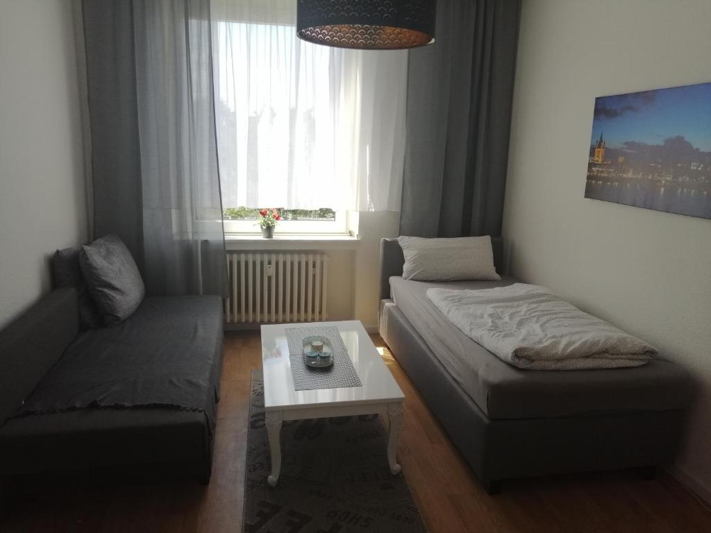 科隆Wohnung in Köln的客房设有床、沙发和桌子。