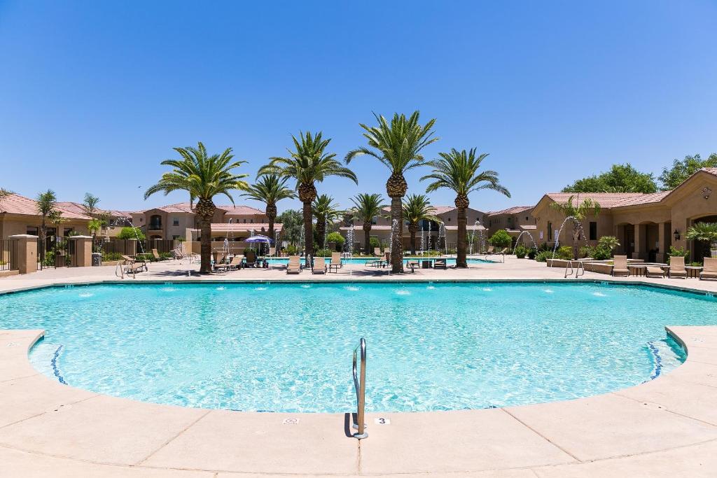 梅萨Mesa Palms Ferro townhouse的度假村内一座种有棕榈树的大型游泳池