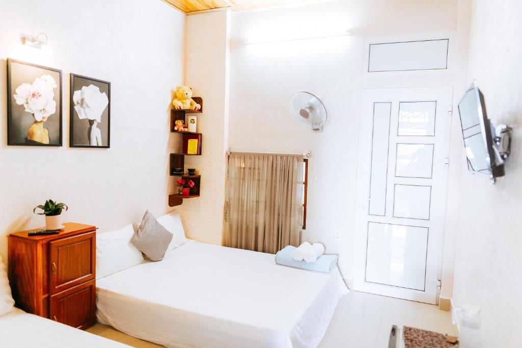 顺化Kota's House Homestay的一间卧室设有两张床和窗户。