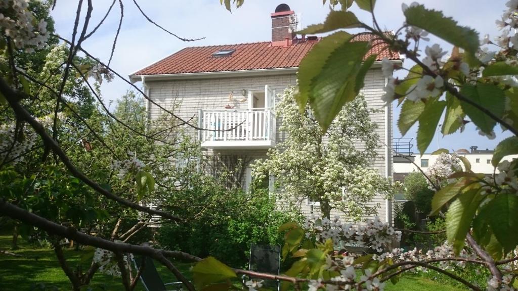 瓦尔贝里Ljust boende, egen ingång och trädgård i centrum的带阳台和树木的白色房屋