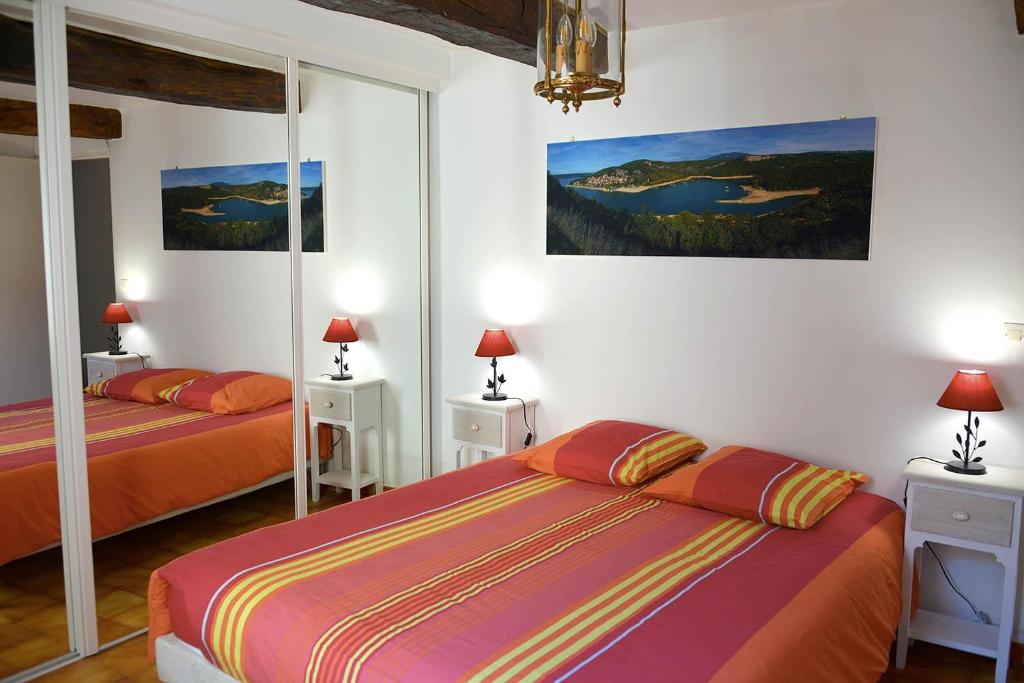 BaudinardMaison CÉDÉJI的一间卧室设有两张床,墙上挂着一幅画