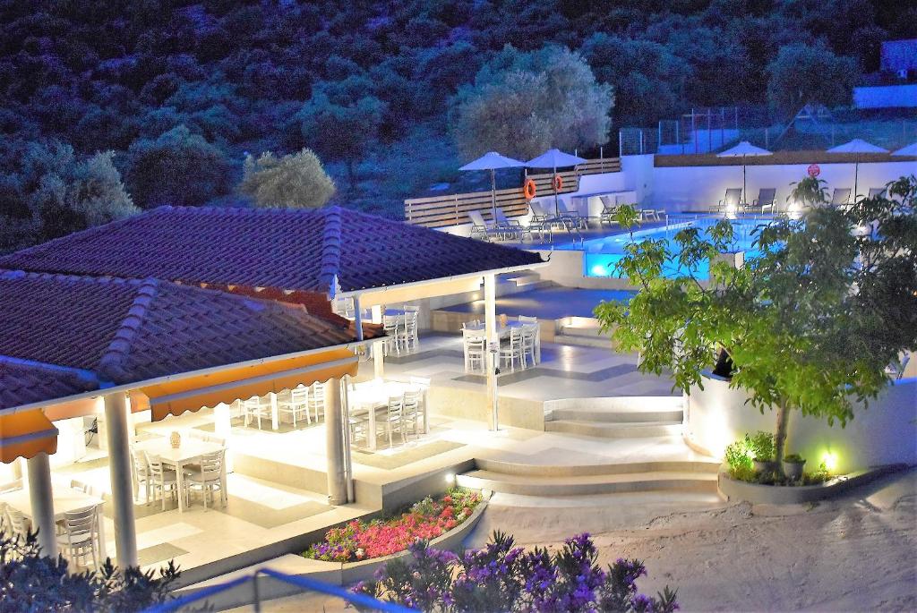 波托什Studios Apartments Irini Patira的享有度假村的空中景色,晚上设有游泳池