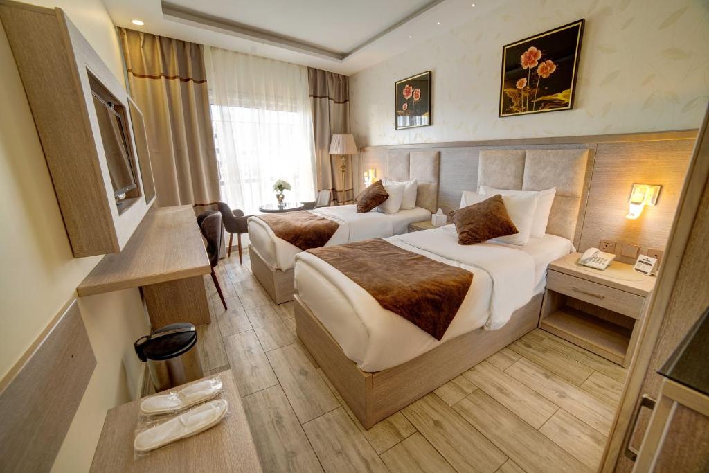 亚喀巴Laverda Hotel的酒店客房设有两张床和电视。