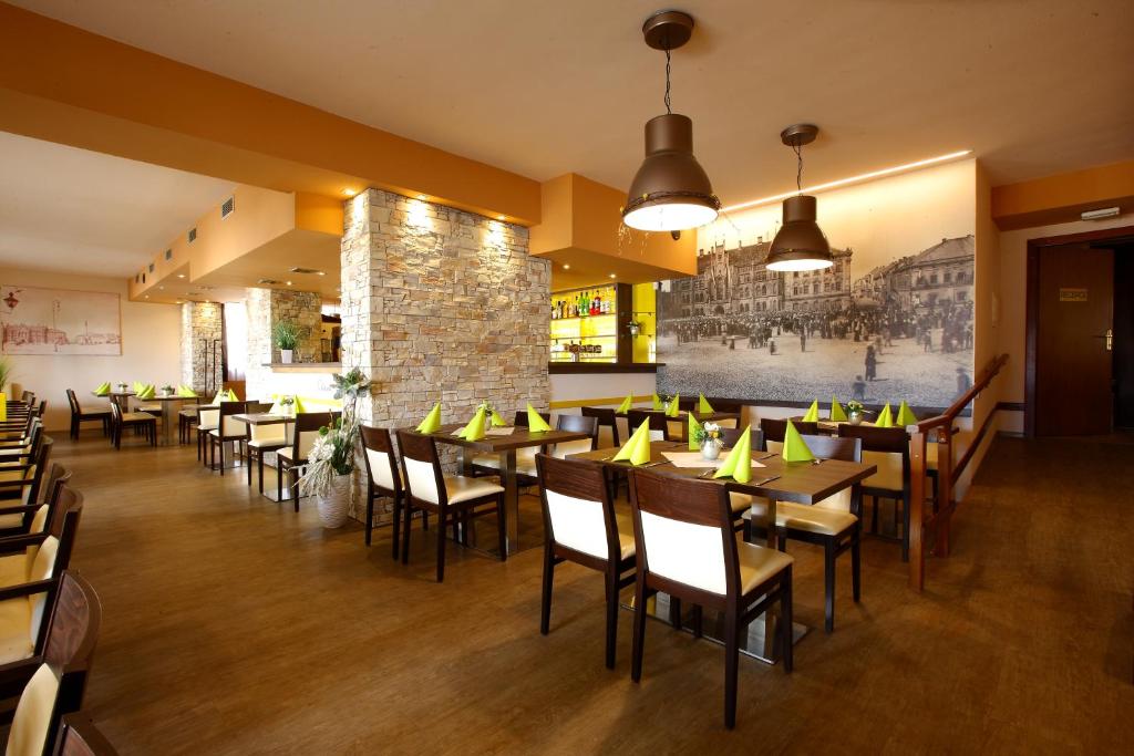 Nový BydžovHotel Classic的一间带桌椅的餐厅以及砖墙